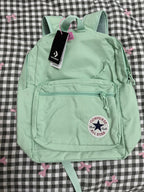 Light green Converse backpack with a tag on a checkered background