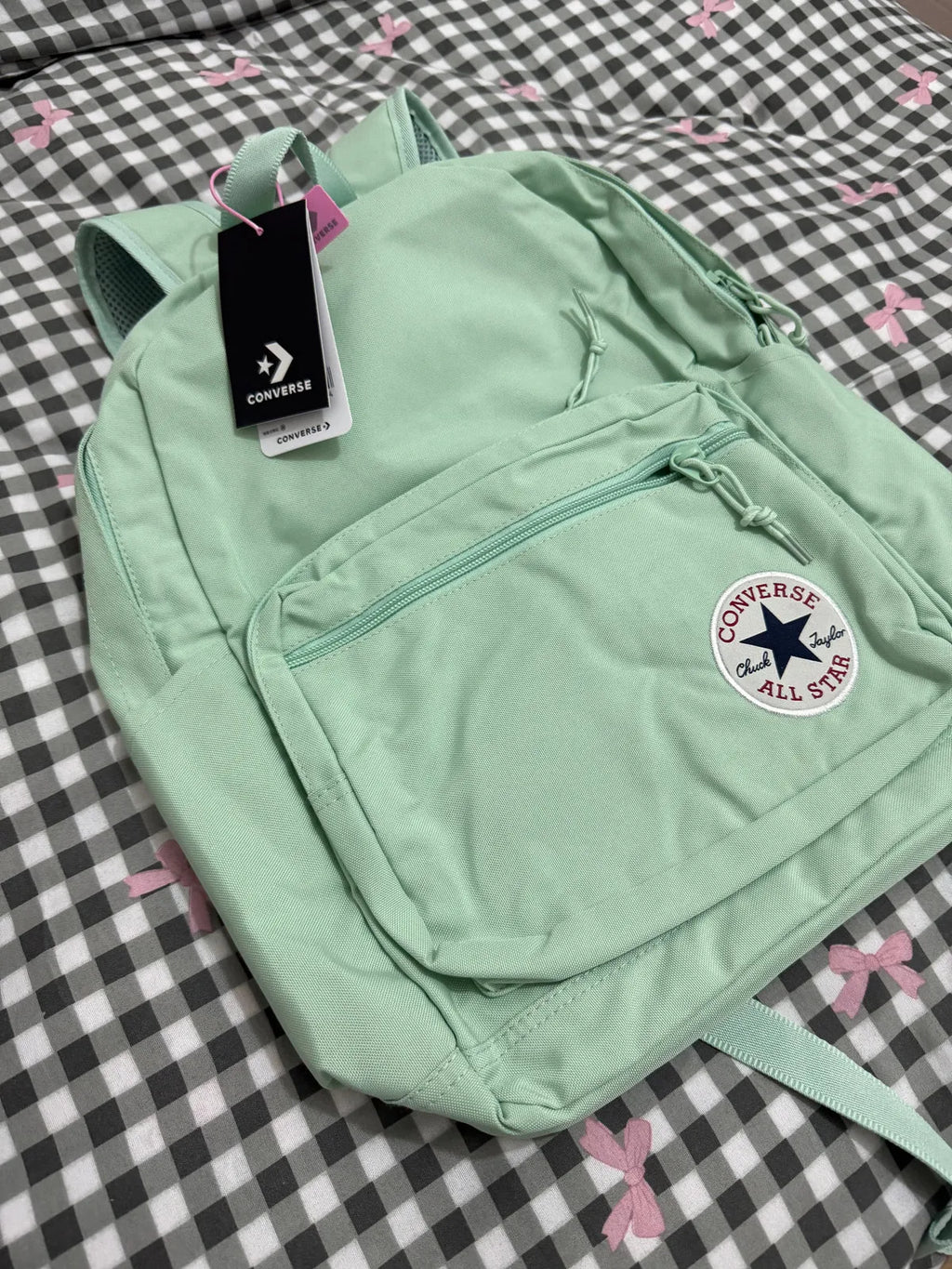 Light green backpack with Converse logo on a checkered background