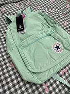 Light green backpack with Converse logo on a checkered background