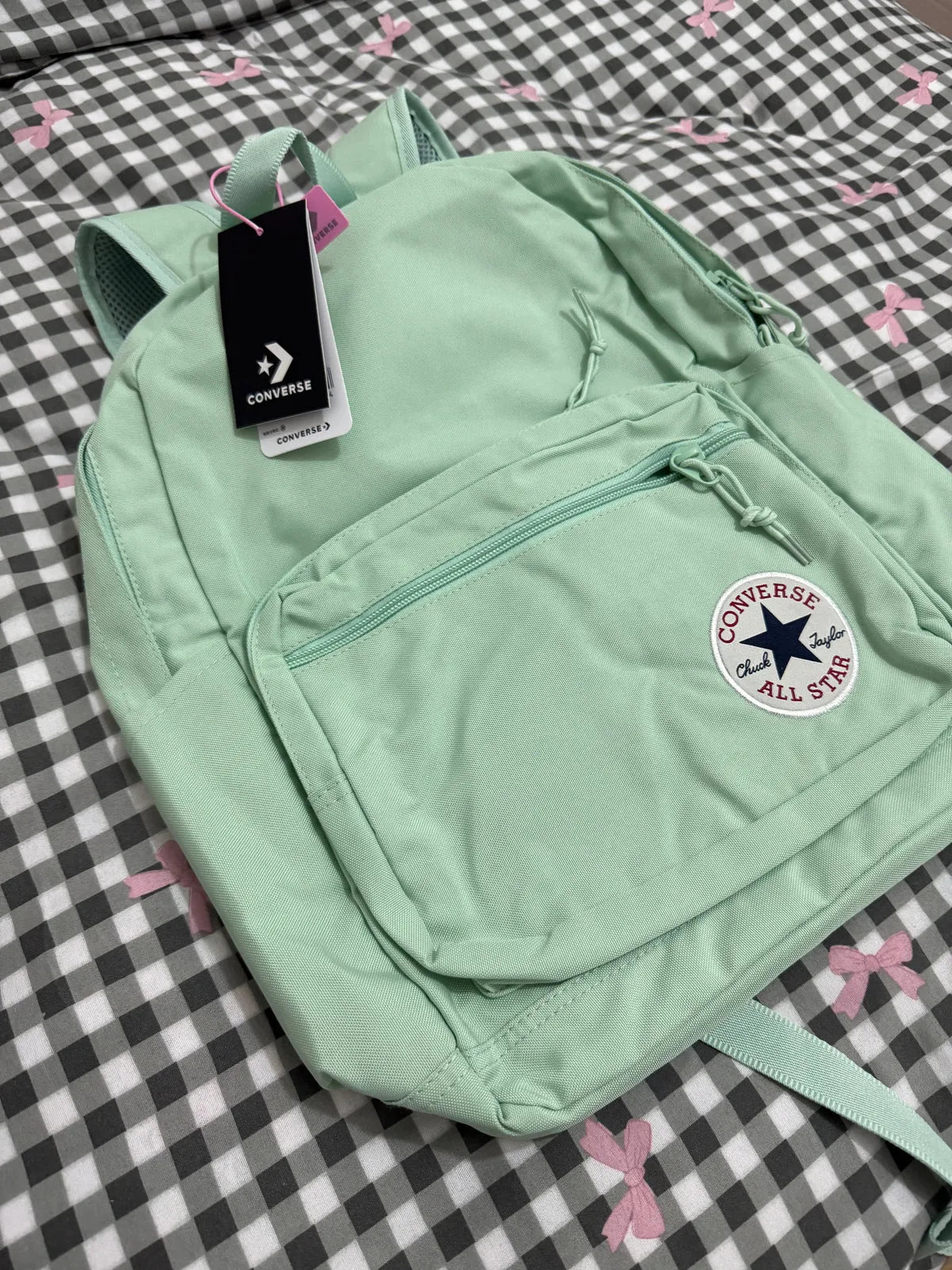 Light green backpack with Converse logo on a checkered background