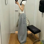 Person wearing gray sweatpants and a white shirt standing in a fitting room.