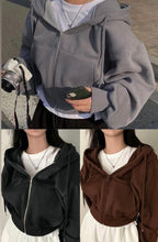 Three views of a person wearing a gray zip-up hoodie with a camera and phone.