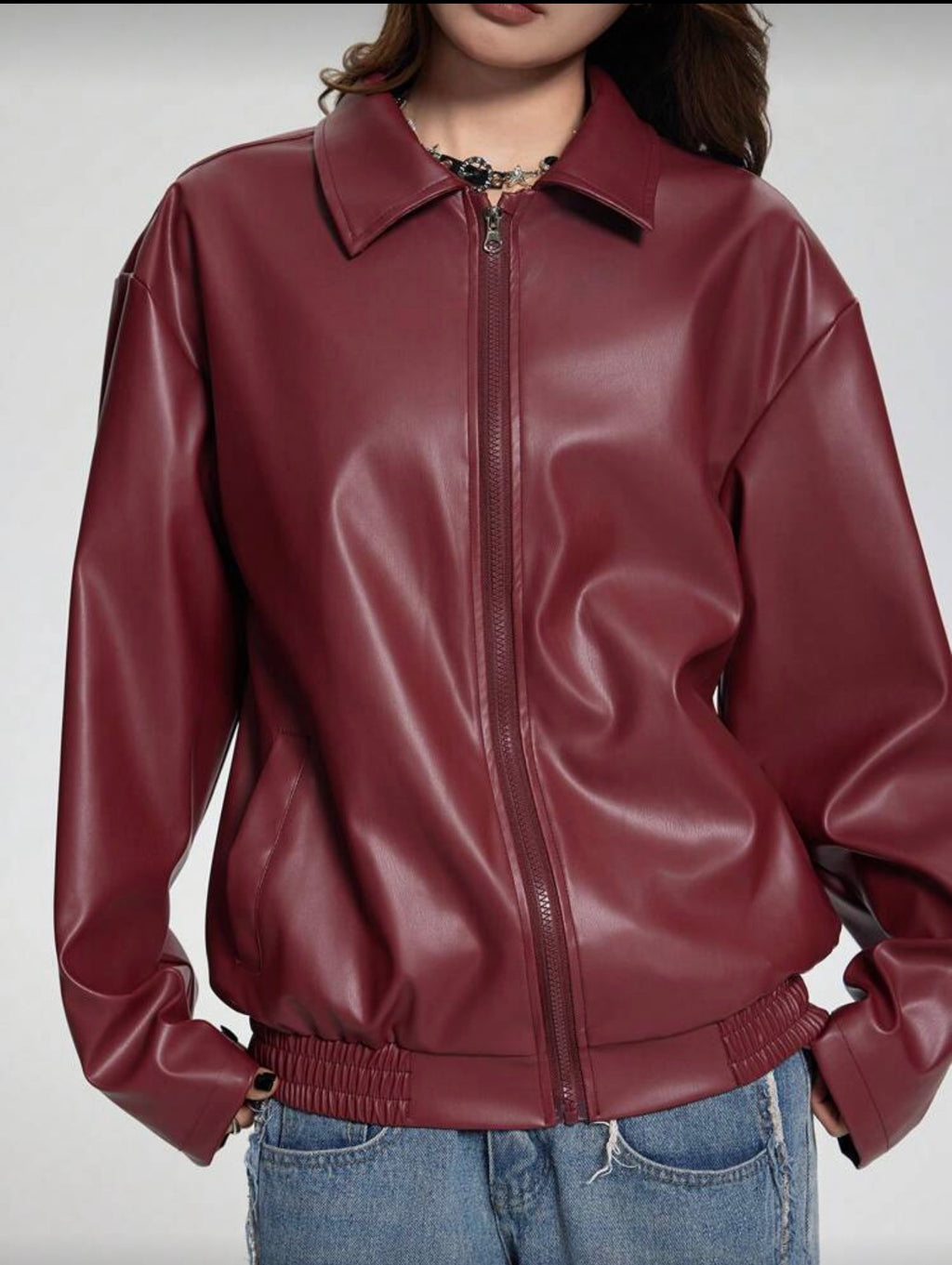 Maroon leather jacket worn by a person on a plain background