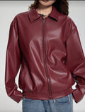 Maroon leather jacket worn by a person on a plain background