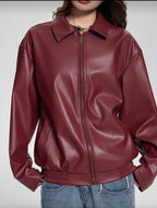 Maroon leather jacket worn by a person on a plain background