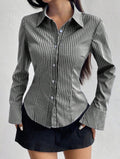Person wearing a gray and white striped shirt with a plain background