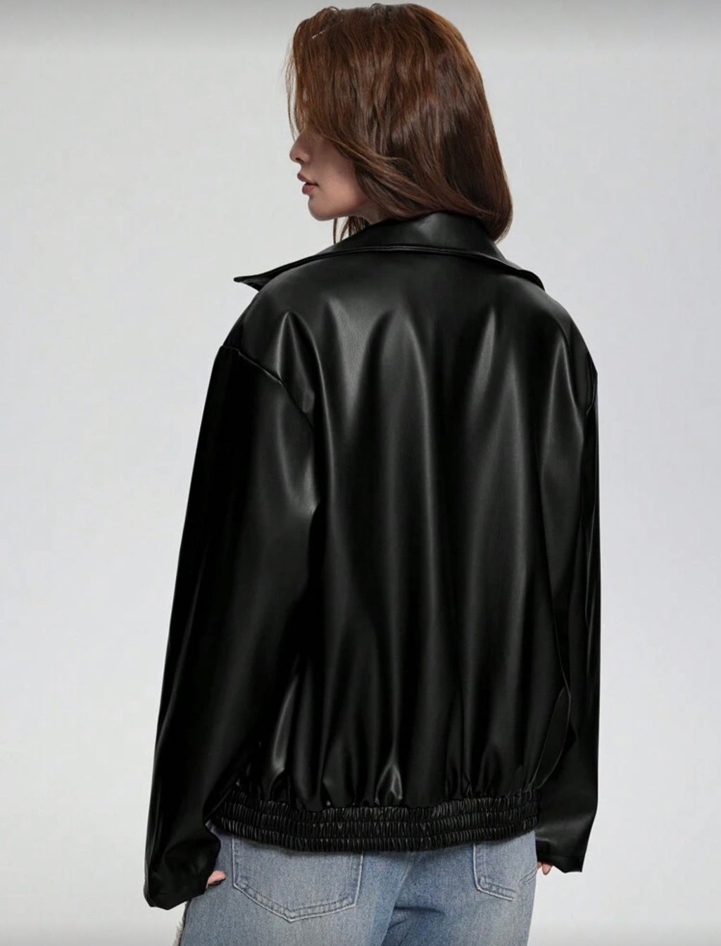 Person wearing a black leather jacket on a plain background