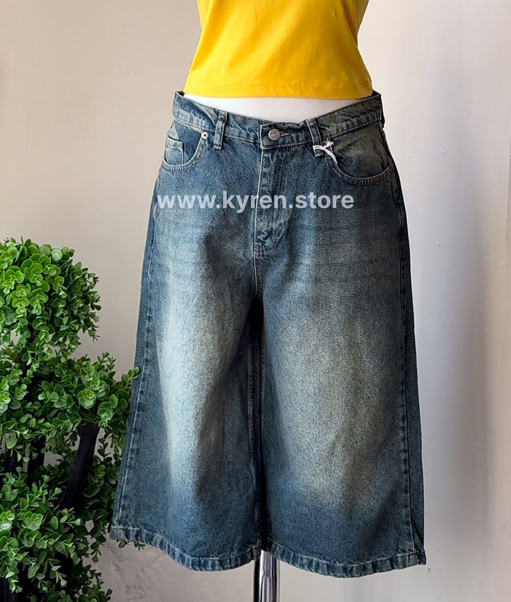 Denim shorts displayed on a stand with a plant in the background