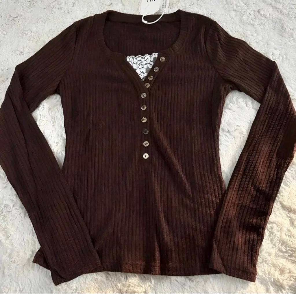 Brown ribbed long-sleeve top with lace detail on a textured surface