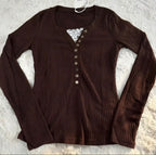 Brown ribbed long-sleeve top with lace detail on a textured surface