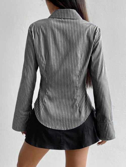 Person wearing a striped blazer and black skirt against a white background