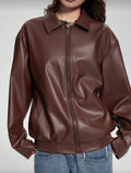 Brown leather jacket worn by a person on a plain background