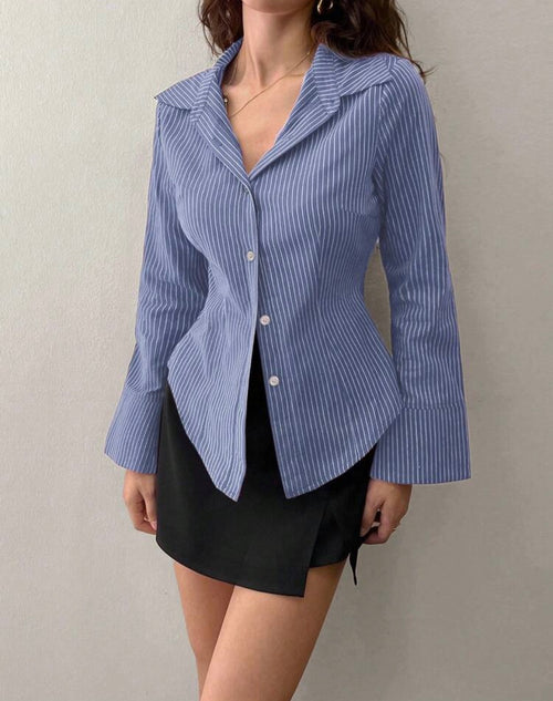 Person wearing a blue and white striped shirt over a black skirt against a plain background