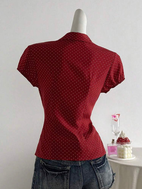 Red polka dot top on a mannequin against a plain background