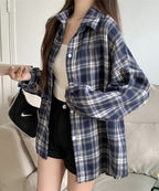 Person wearing a blue plaid shirt in a casual indoor setting