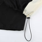 Black drawstring bag with a white corner on a light gray background