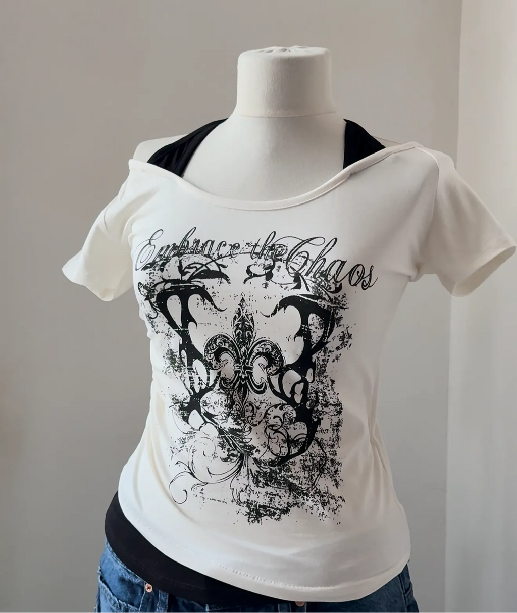 White t-shirt with black graphic design on a mannequin against a plain background