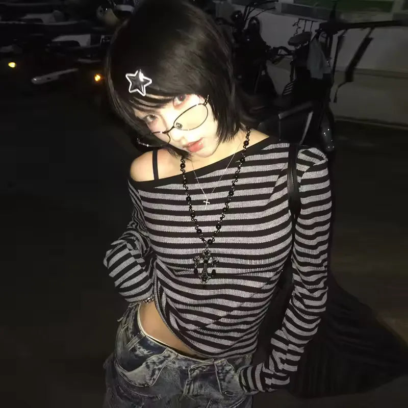 Person wearing a black and white striped shirt with a star hair accessory in a dark setting.