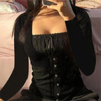 Person wearing a black corset-style outfit with long sleeves.
