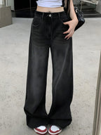 Person wearing black wide-leg jeans with a white background