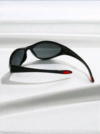 Black sunglasses with red accents on a white surface