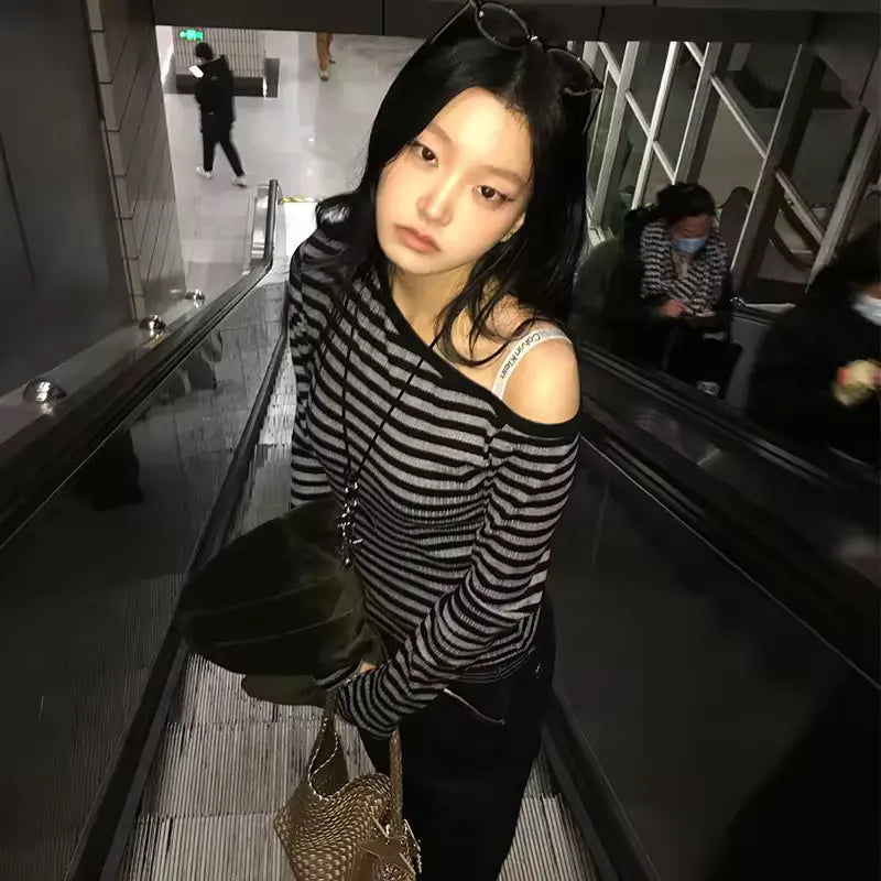 Woman in a striped sweater standing on an escalator