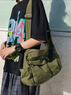Person holding a green bag with a colorful 'D14' design on a black shirt.