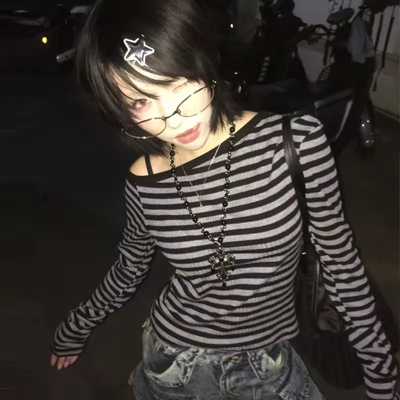 Person wearing a black and white striped shirt with a star hair accessory in a dark setting