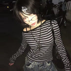 Person wearing a black and white striped shirt with a star hair accessory in a dark setting