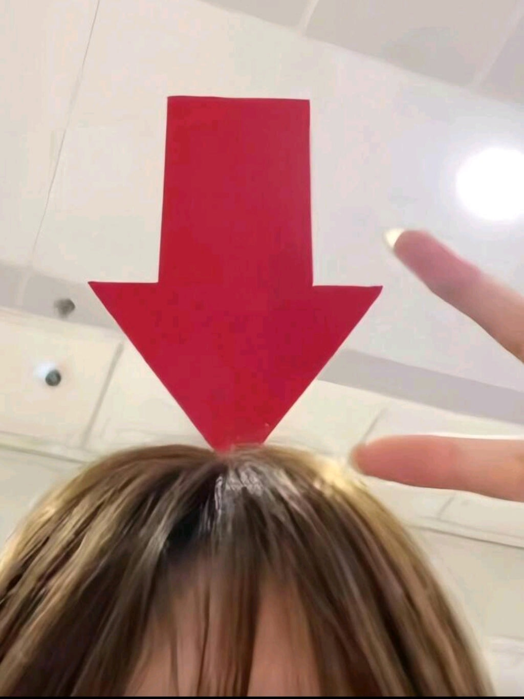 Red arrow on a tiled floor with a person pointing at it