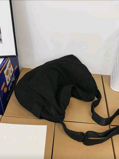 Black bag on a tiled floor with a white wall in the background
