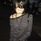 Person wearing a black and white striped shirt with a star hair accessory in a dark setting